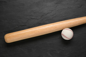 Baseball bat and ball on black background, top view. Sports equipment