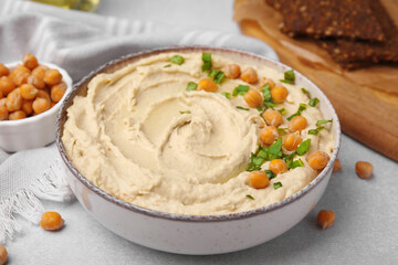 Delicious hummus with chickpeas served on light grey table