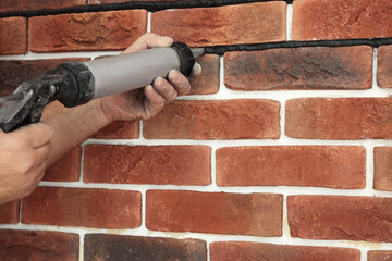 Professional builder using tiling fugue for grouting, closeup