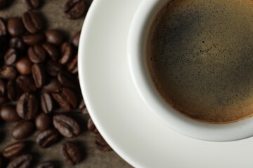 Cup of aromatic coffee on wooden table, top view. Space for text