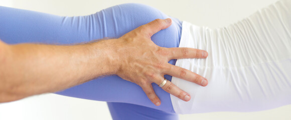 Fototapeta premium Young woman exercising during physiotherapy with help of physiotherapist in the hospital