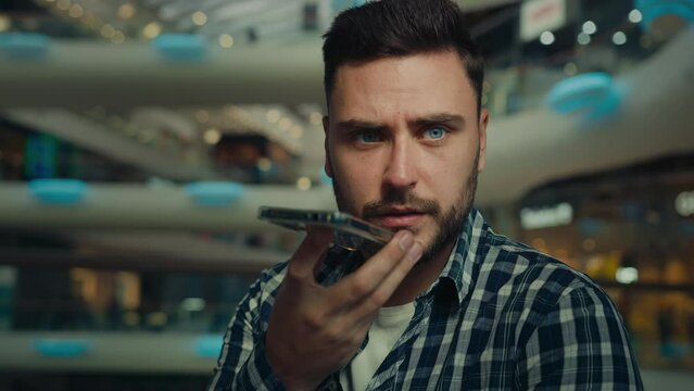 Close up young man hold mobile phone say speech record voice message talk on speakerphone wireless send voicemail online Arabian guy user give audio command to smartphone ai searching data at internet