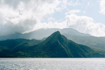 View of tree covered hills and mountains in Caribbeans. Rainforest land along waters of Atlantic Ocean