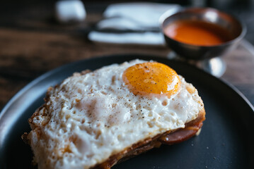 Toast with cheese and sausage covered with fried egg