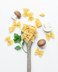 Raw pasta with mushrooms and parmesan in a wooden spoon on a white background