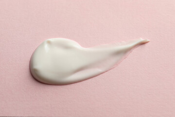 Sample of face cream on pink background, top view