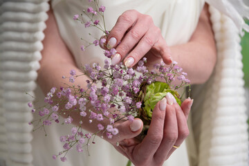 wedding manicure for the bride, a girl in a wedding dress holds a bouquet