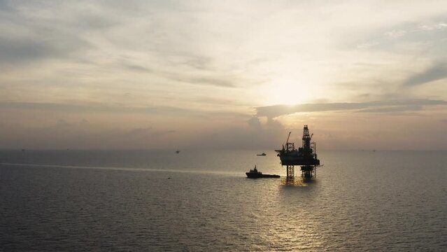 Jack up drilling rig and production platform in the middle of the ocean at sunrise time
