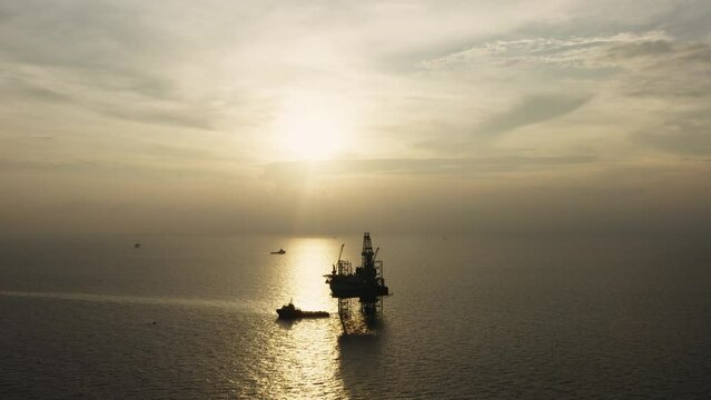 Jack up drilling rig and production platform in the middle of the ocean at sunrise time
