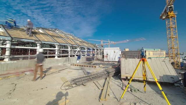Construction worker using theodolite surveying optical instrument panoramic timelapse. Builders and carpenters in uniform working on the roof. Measuring angles in horizontal and vertical planes on