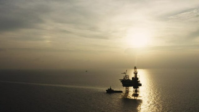 Jack up drilling rig and production platform in the middle of the ocean at sunrise time
