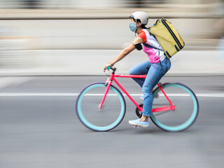 Naklejka na ściany i meble Blurred silhouette of a female cyclist on a city street
