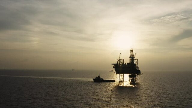 Jack up drilling rig and production platform in the middle of the ocean at sunrise time
