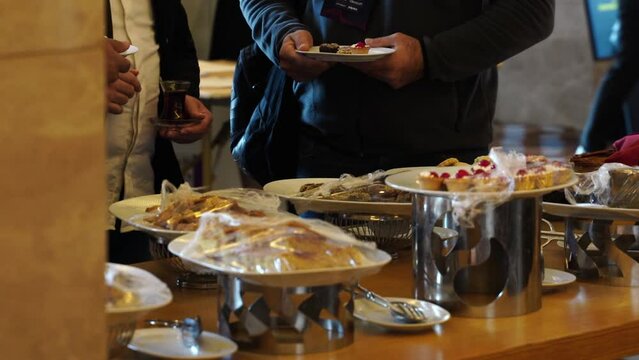 Buffet desserts at the hotel. Desserts at the open buffet, luxury hotel concept. cooking. the waiter, in protective gloves , There are drinks and snacks on the table.
