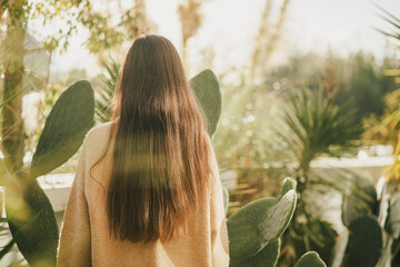 Young woman with long healthy hair enjoying sunset outdoors.