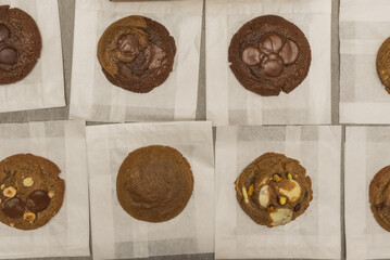 A pile of different flavored chocolate chip cookies viewed from the top