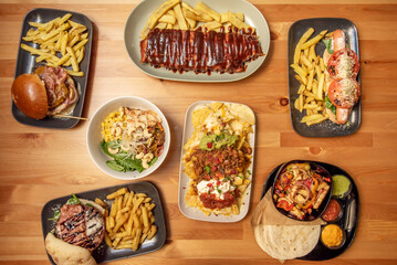 A set of tex mex food recipes with grilled burgers, ribs with barbecue sauce, salads and nachos with chili and guacamole