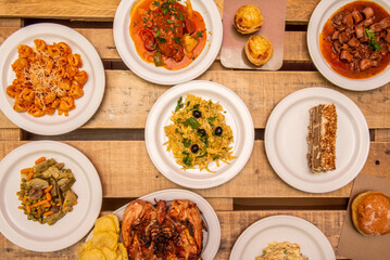 Typical Spanish tapas dishes with salad, vegetable stew, cod stew, golden cod, calamari in its ink, grilled chicken unvarnished wooden planks