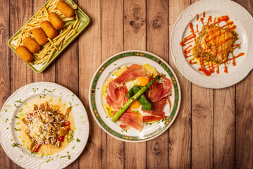 Set of delicious Mediterranean gastronomy recipes with scrambled eggs with ham, Iberian ham...