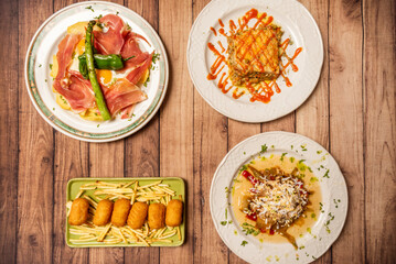 Set of delicious recipes of Mediterranean gastronomy with bechamel and chicken croquettes, Iberian soap with eggs and potatoes on wooden table