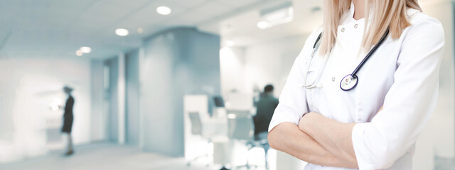 Medical wide banner with copyspace for text. Cropped caucasian woman doctor in white uniform. Blurred clinic on background. Healthcare, pharmacology concept.