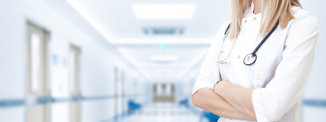 Medical wide banner with copyspace for text. Cropped caucasian woman doctor in white uniform. Blurred clinic on background. Healthcare, pharmacology concept.