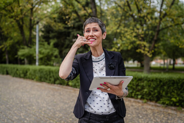 one woman mature senior caucasian female use digital tablet outdoor