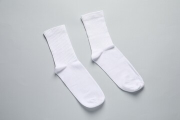 Pair of white socks on light grey background, flat lay