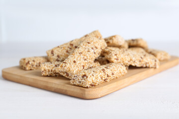 Tasty sesame seed bars on white wooden table