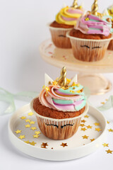 Cute sweet unicorn cupcakes on white table