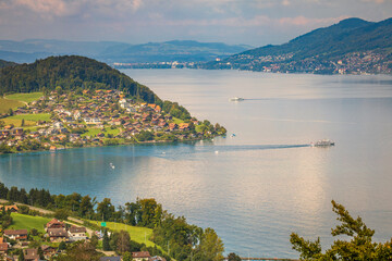 Aerial view of Swiss Alps and Lake Thun with ferry boat at sunset, Interlaken