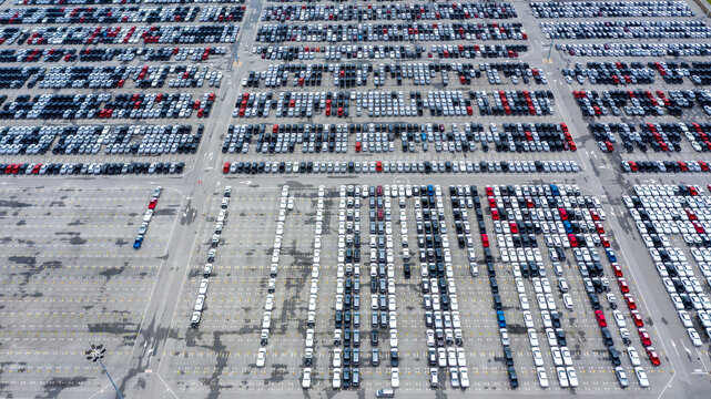 Aerial view car for sale stock lot row. Car dealer inventory, Car lined up at port import export business logistic dealership, Automobile and automotive car parking lot commercial business industry.