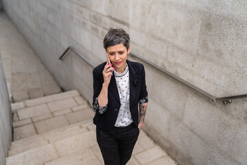 Obraz premium One modern caucasian mature or senior woman making phone call outdoor