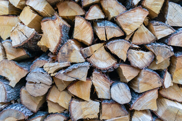 Fototapeta premium Neatly folded woodpile of dry firewood close-up. Procurement of fuel for cold home heating baths alternative heating. Natural wood texture eco background. chopped firewood for fireplace