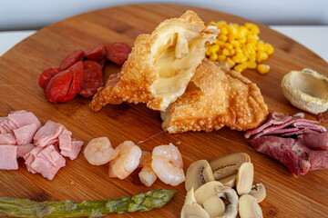 tabla de comida variada, empanada, carnes frías, verduras, camarones