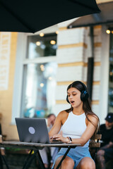 Beautiful woman working on laptop at outdoors cafe