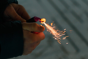 Burning Firecracker with Sparks. Guy Holding a Petard in a Hand. Loud and Dangerous New Year's...
