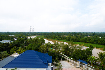 aerial view of Villa house in the middle of the garden with blue tile roof and the river at Mekong...