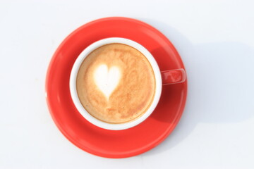 Cafe Latte Art, love shape on a cafe latte. Hot Cafe latte in a red cup