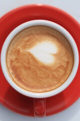 Cafe Latte Art, love shape on a cafe latte. Hot Cafe latte in a red cup