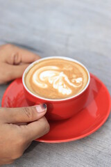 a glass of hot cafe latte with latte art in the morning