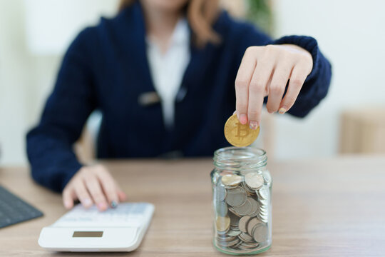 Cryptocurrency savings plan, Asian young woman saving digital coins into a piggy bank - Powered by Adobe