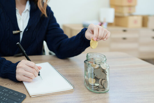 Cryptocurrency savings plan, Asian young woman saving digital coins into a piggy bank - Powered by Adobe