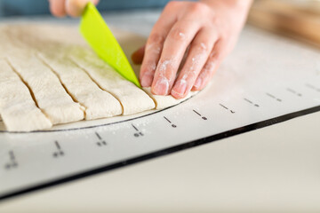 Close-up of cutting the rolled dough into equal parts according to the markup, copy space.