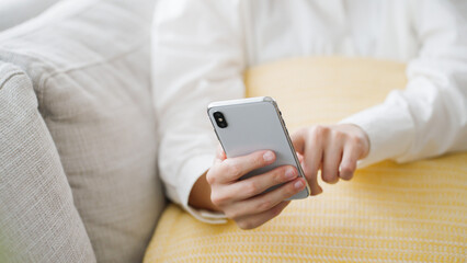 スマートフォンを操作するミドル女性..