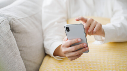 スマートフォンを操作するミドル女性..