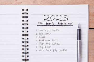 List of New Year's resolution on notepad, vintage style on wood with space for layout.