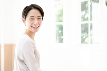 窓際で振り返って微笑む女性