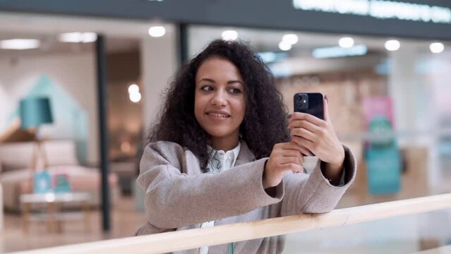 young woman taking a selfie in a modern shopping mall.