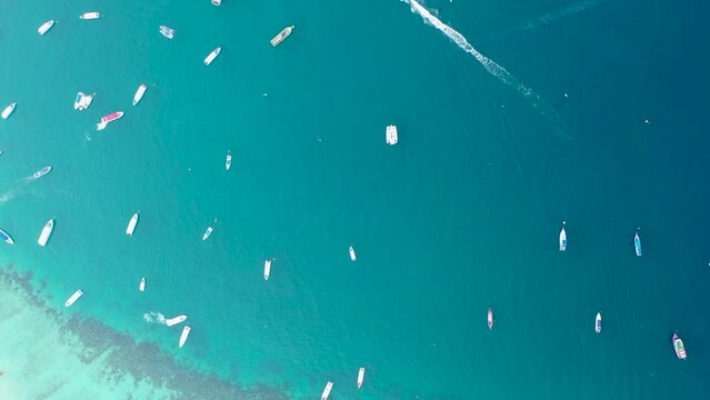 Aerial top-down drone view of colorful Thailand traditional long tail boats parked in one line at the pier with crystal clear blue ocean water at phi phi island 4k